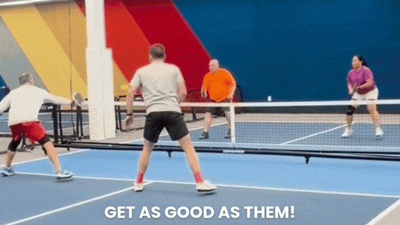 Doubles partners volleying at the net at Dink Pickleball in Kingston